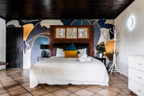 a bedroom with a large bed with a colorful wall at Gillys Accommodation in Camperdown