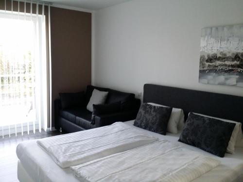 a bedroom with a large bed and a couch at HD City Apartments in Heidelberg