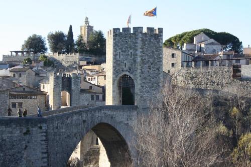 a stone bridge over a city with a castle at Cal Arxè in Besalú