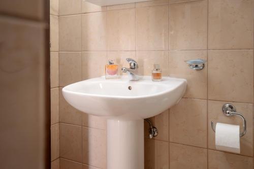 a bathroom with a white sink and a shower at Guesthouse Wish in Stari Grad