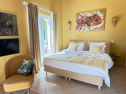 a bedroom with a bed and a tv and a window at Boutique Guesthouse-Moncarapacho in Moncarapacho