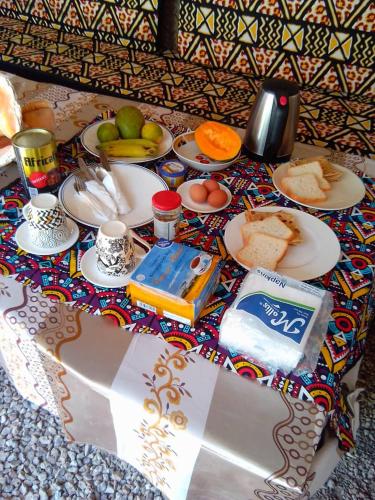 a table topped with plates of food and fruit at Arham Nungwi Beach in Nungwi
