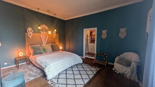 a bedroom with a bed and a blue wall at L'héritage in Champdeniers