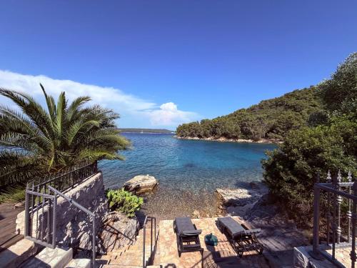 a view of a beach with chairs and the water at Villa Mala Dora in Stari Grad