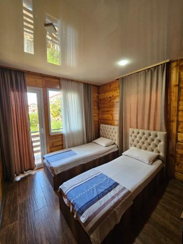 two beds in a room with two windows at Guesthouse Sunshine Ureki in Ureki