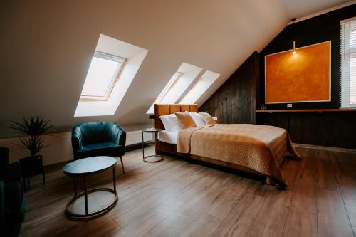 a bedroom with a bed and a chair at Diamond Boutique Hotel in Pruszcz Gdański