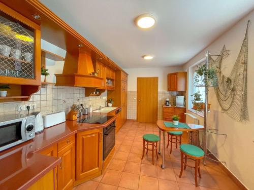 a kitchen with wooden cabinets and a table and chairs at Zöldpart Villa in Balatonszárszó