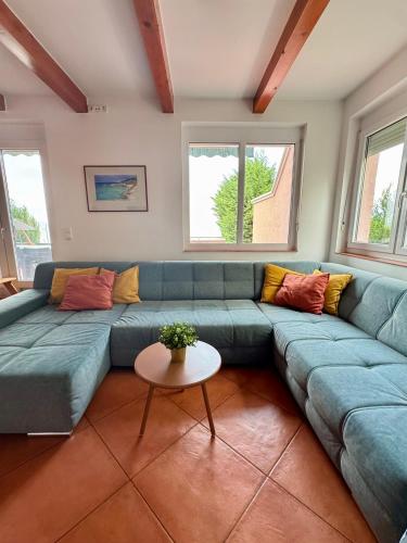 a living room with a blue couch and a table at Zöldpart Villa in Balatonszárszó