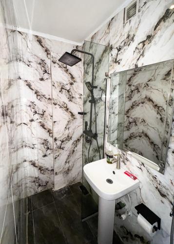 a bathroom with a sink and a mirror at Luxe Apartments Surulere in Lagos