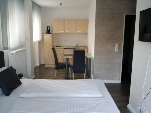 ein Schlafzimmer mit einem Bett und einem Tisch sowie eine Küche in der Unterkunft HD City Apartments in Heidelberg