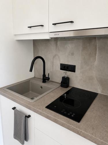 a kitchen counter with a sink and a stove at Salsedo Seaside Rooms 3 in Kanali