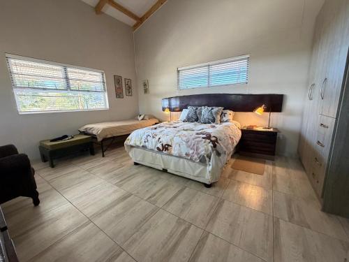 a bedroom with a large bed and a desk at Karibu Self-Catering Unit 1 in Omaruru