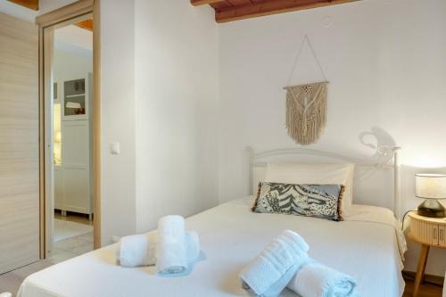 a bedroom with a white bed with towels on it at Consolato House in Patmos