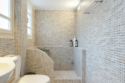 a bathroom with a shower with a toilet and a sink at Consolato House in Patmos