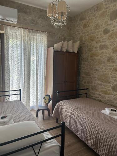 a bedroom with two beds and a chandelier at Fanouria's home in Kalleryianá