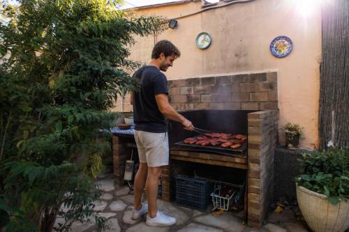 a man cooking food in an outdoor oven at CASA FLORIT - Citrus Villa - BBQ & POOL - 5 Guests in La Eliana