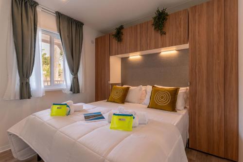 a bedroom with a large white bed with yellow pillows at Club del Sole Viareggio Family Collection in Torre del Lago Puccini