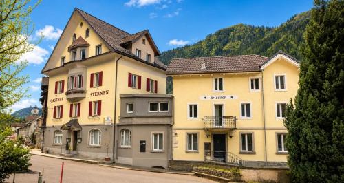 a row of buildings on a street with a mountain at Hotel Sternen Gurtnellen AG in Gurtnellen