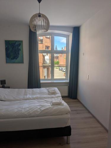 a bedroom with a bed and a large window at Stubbekøbing Square View Stopover in Stubbekøbing