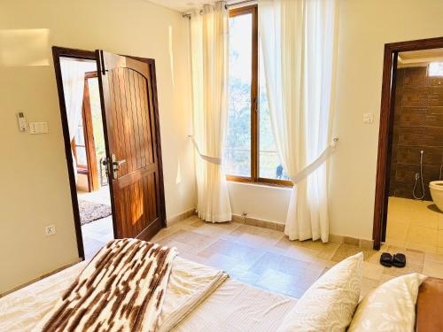 a bedroom with a bed and a large window at Highland by Gunner Lodges in Patriata