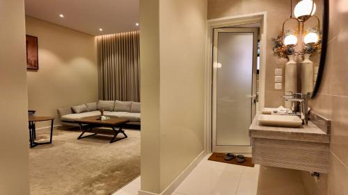a bathroom with a sink and a living room at نزل ليلى الفندقية الفاخرة luxury in Abha