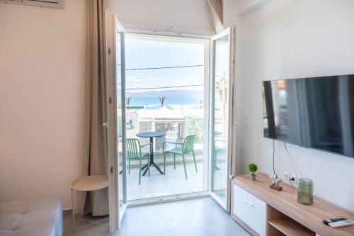 a living room with a sliding glass door leading to a patio at Vrachati Blue in Vrachati
