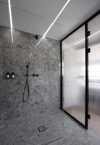 a shower in a bathroom with a glass wall at Hotel Bleibe in Freudenberg am Main