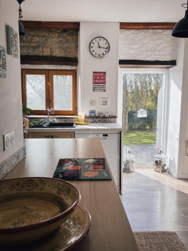a kitchen with a counter and a clock on the wall at Le Marronnier in Montchauvet