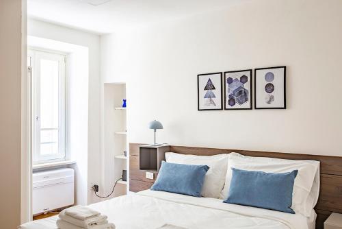 a bedroom with a bed with two blue pillows at Lake Como with view, sauna and air conditioning in Mandello del Lario