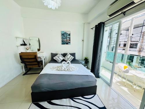 a bedroom with a bed and a large window at The Sunset Bangsaen in Ban Rong Khoei