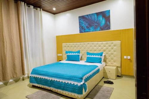 a bedroom with a bed with blue pillows at Poolside View Guest House in Kigali