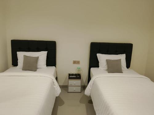 two beds sitting next to each other in a room at Priority Teuku Umar Samarinda in Loa Bakong