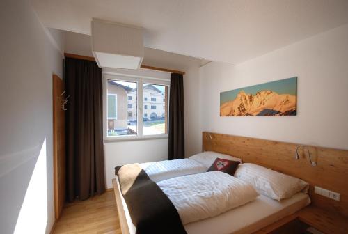 Schlafzimmer mit einem Bett und einem Fenster in der Unterkunft EdelWeiss AlpinLodge in Matrei in Osttirol