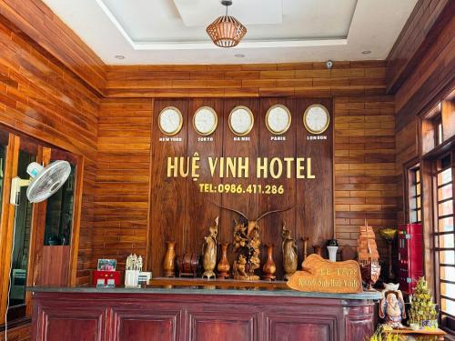 a restaurant with a wall with clocks on it at Huệ Vinh Hotel in Cửa Lô