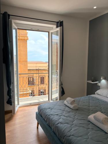 a bedroom with a bed and a large window at Eirenè Peaceful Suites in Agrigento