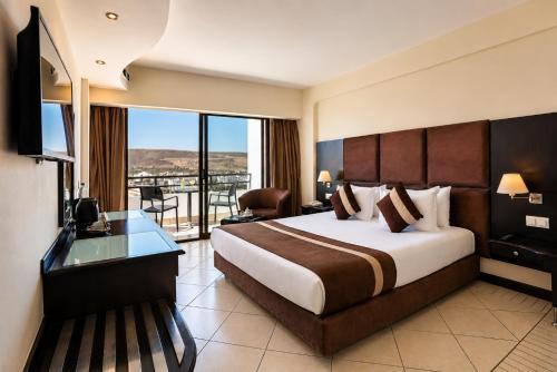 a hotel room with a large bed and a balcony at Anezi Tower Hotel in Agadir