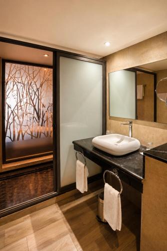 a bathroom with a sink and a large mirror at Anezi Tower Hotel in Agadir