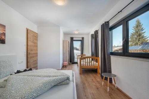 a bedroom with a bed and a large window at Mountain Chalet Top 3- mit Garten und Grill in Fieberbrunn