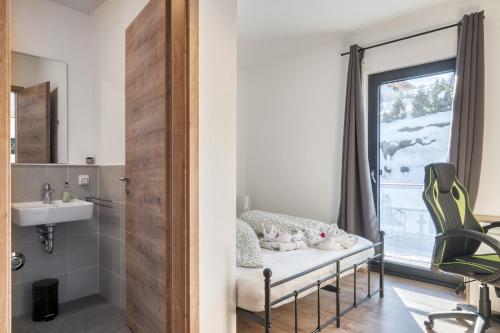a bathroom with a bed and a sink and a window at Mountain Chalet Top 3- mit Garten und Grill in Fieberbrunn