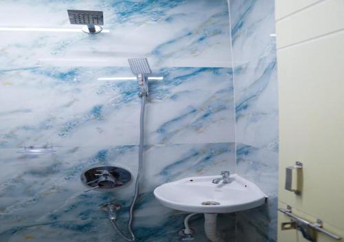 a bathroom with a sink and a shower at NRI Hotels & Coliving in Hyderabad