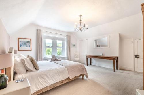 a white bedroom with a bed and a desk at 4 Bed in Matlock oc-52094 in Highpeak Junction