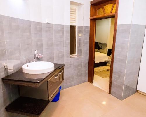 a bathroom with a sink and a mirror at Poolside View Guest House in Kigali