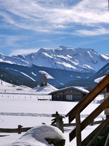 a snow covered mountain with a house in the background at Urgemütliche Lennkhütte in Rauris