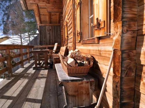 a porch of a log cabin with a bench and a window at Urgemütliche Lennkhütte in Rauris