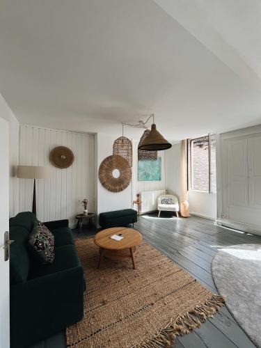 a living room with a green couch and a table at Le Haut des Halles in Martel