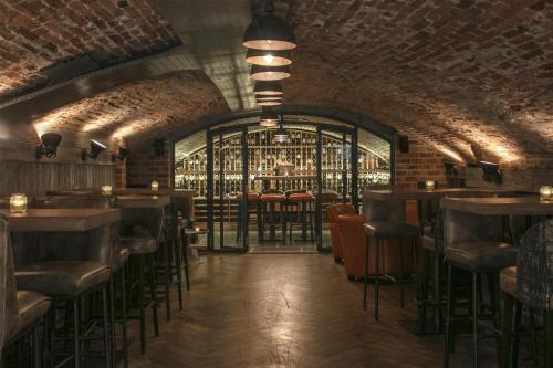 a bar with tables and chairs and a brick wall at Best Western Moores Central Hotel in St. Peter Port