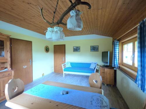 a living room with a bed and a blue couch at Blockhaus Hipp in Steingaden