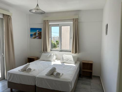 a bedroom with two beds and a window at Kaloxenia in Kardamaina
