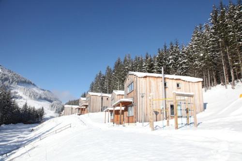 a row of wooden buildings in the snow at Hüttendorf Präbichl 1 in Vordernberg