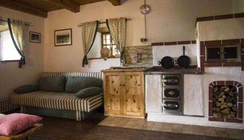 a living room with a couch and a stove at Ferienhaus Staller Brendl in Sankt Georgen in Obdachegg